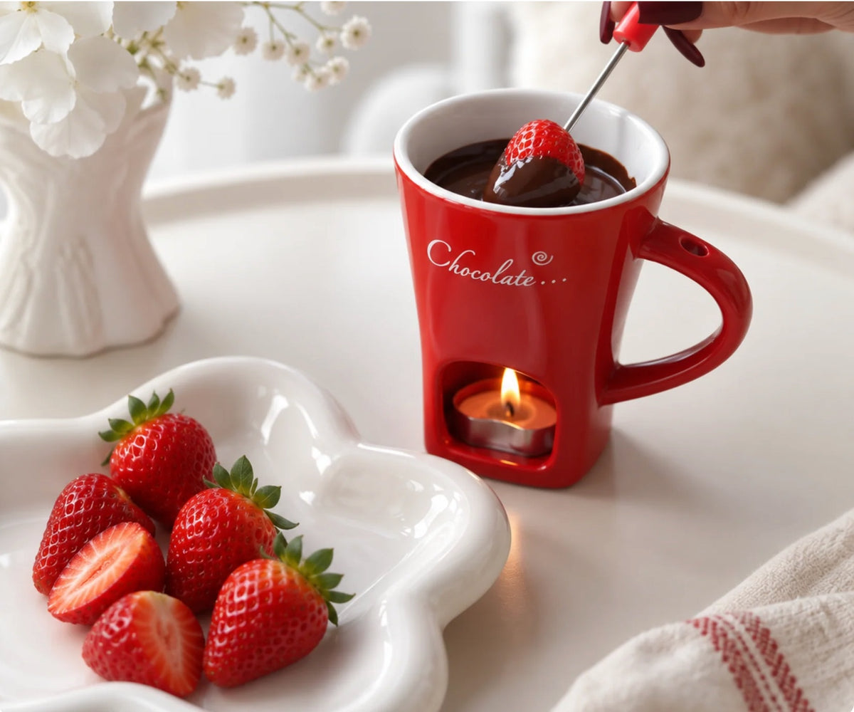 Fresa mojada en chocolate fundido en la taza fondue roja